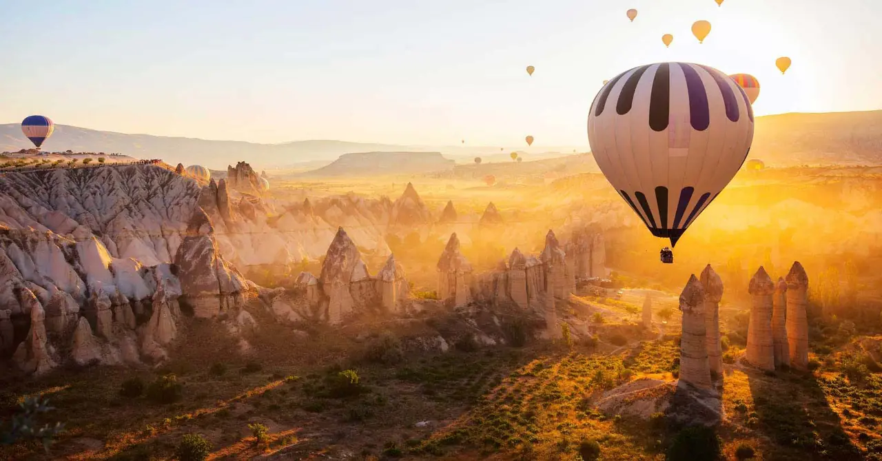 Kapadokya'da gün doğumunda peri bacalarının üzerinde uçan sıcak hava balonları